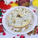 Close-up of Meetha Ghewar soaked in sugar syrup with almond and pistachio garnish