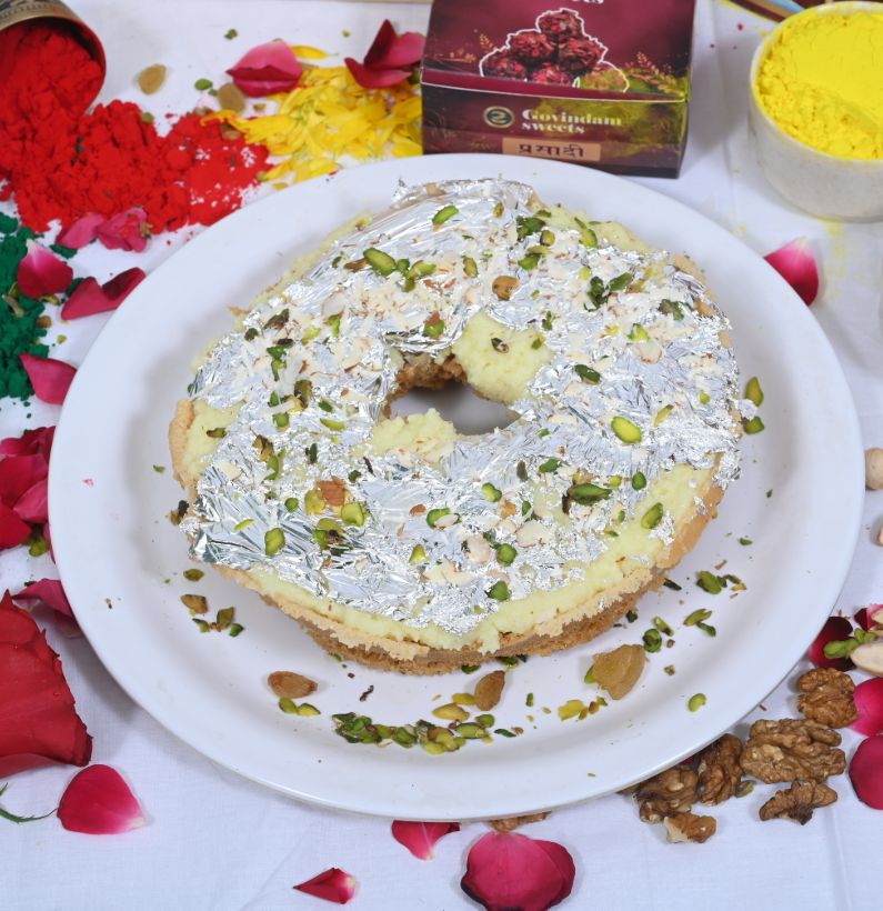 Close-up of Meetha Ghewar soaked in sugar syrup with almond and pistachio garnish