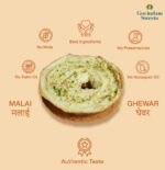 Close-up of Malai Ghewar topped with thick rabri and chopped dry fruits