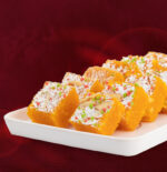 Mohan Thal pieces packed in decorative gift box with golden wrapper